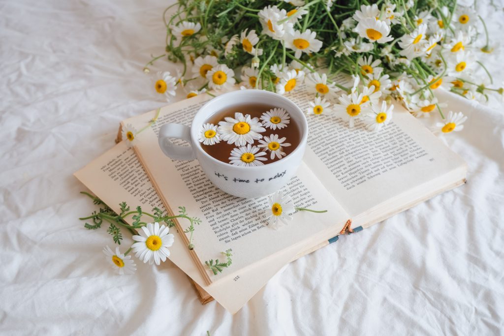 Chamomile tea and flowers and a book