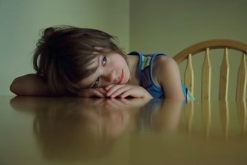 Young girl resting her head on a table