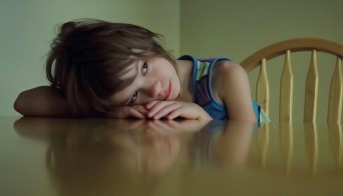 Young girl resting her head on a table